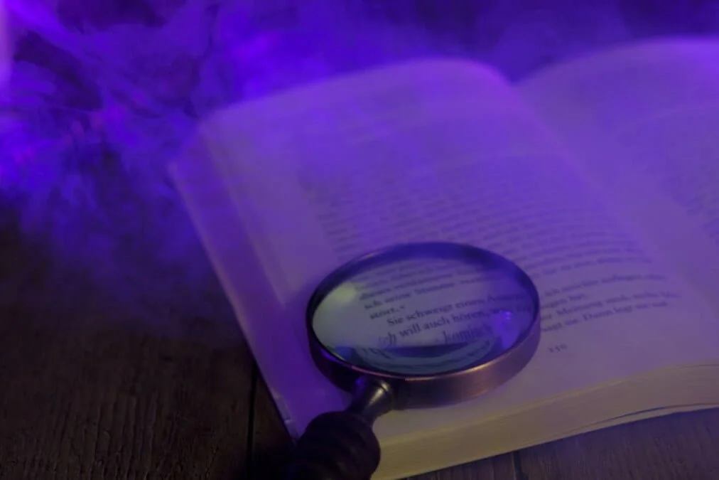 Open book with magnifying class